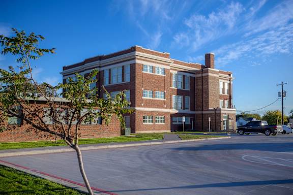 A red brick building with a tree in front of it.
