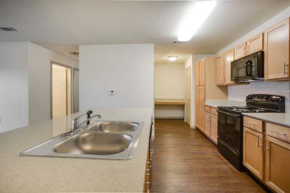 A kitchen with a sink and a stove top oven.