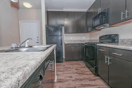 A kitchen with a granite countertop and stainless steel appliances.