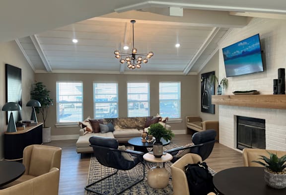 A living room with a fireplace and a television mounted on the wall.
