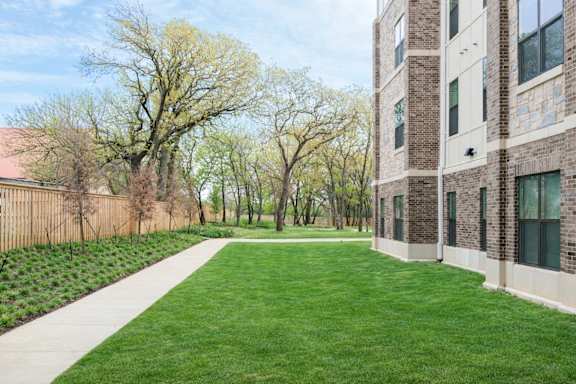 A grassy area in front of a brick building.