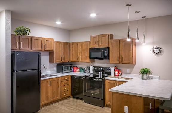 A kitchen with wooden cabinets and black appliances.