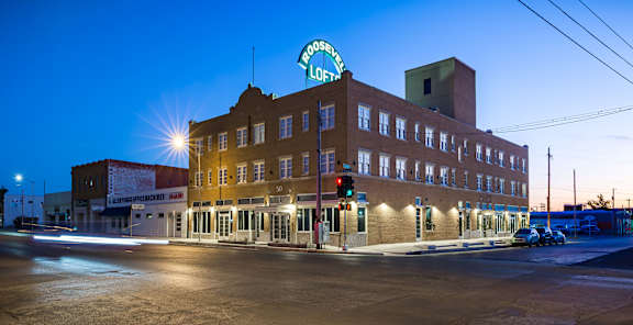 A building with a lit up sign that says Roosevelt Lofts.