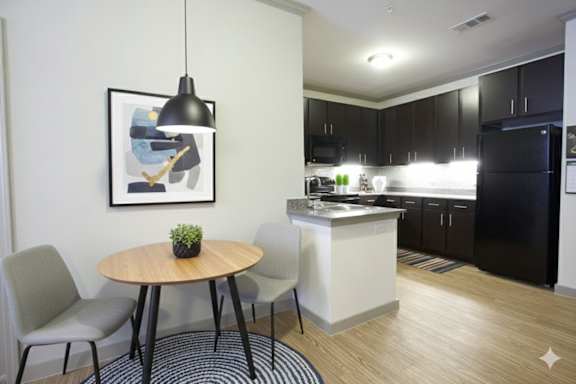 A modern kitchen with a dining table and chairs.