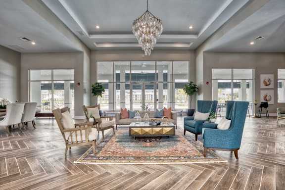 A large, well-lit room with a variety of seating options and a chandelier.