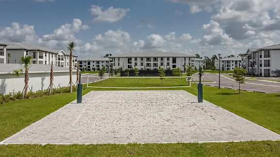 A courtyard with a paved walkway and grassy area in front of apartment buildings.