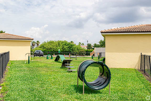 A playground with a green slide and picnic table.