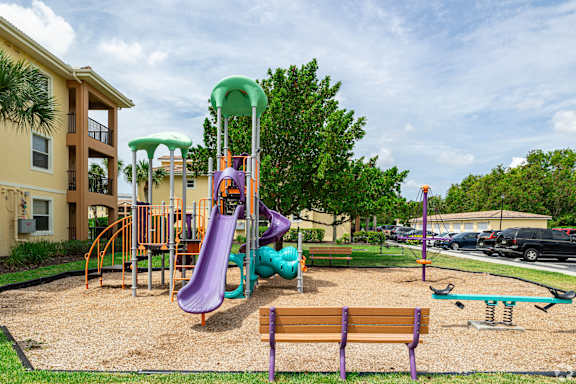 A playground with a purple slide and a green canopy.