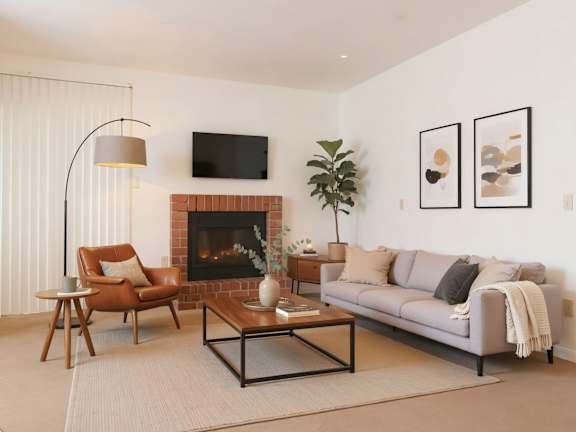 A living room with a fireplace, a couch, a chair, and a coffee table.