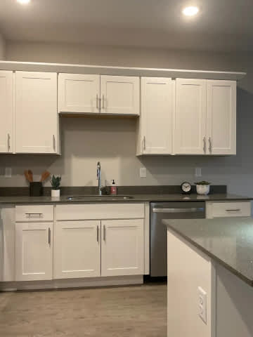 A kitchen with white cabinets and a granite countertop.