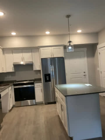 A kitchen with a stainless steel refrigerator and a stainless steel dishwasher.