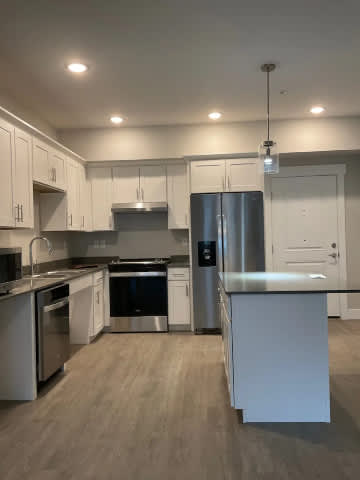 A kitchen with white cabinets and stainless steel appliances.