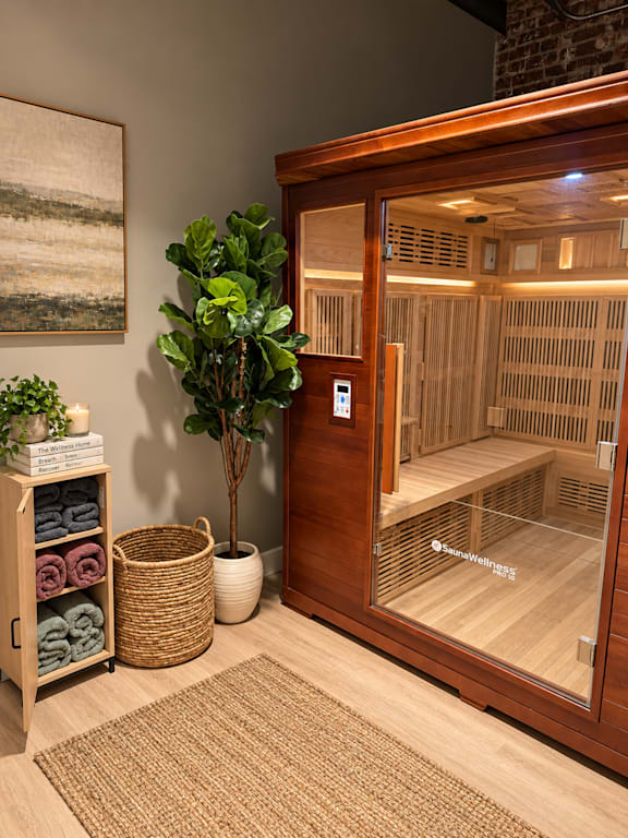 A room with a wooden door leading to a sauna.