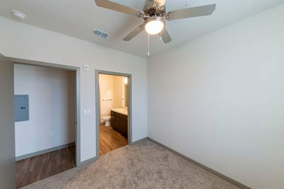 A room with a ceiling fan and a carpeted floor.