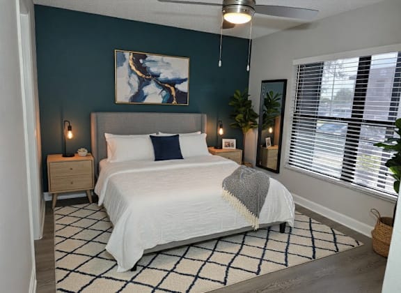 A bedroom with a large bed and a painting on the wall.