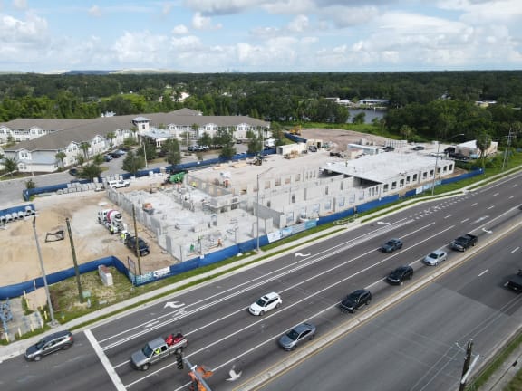 an aerial view of an empty parking lot with cars parked in front of a building