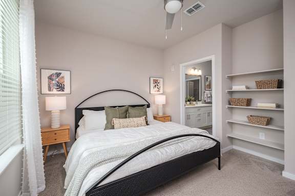 A bedroom with a large bed and a mirror on the wall.