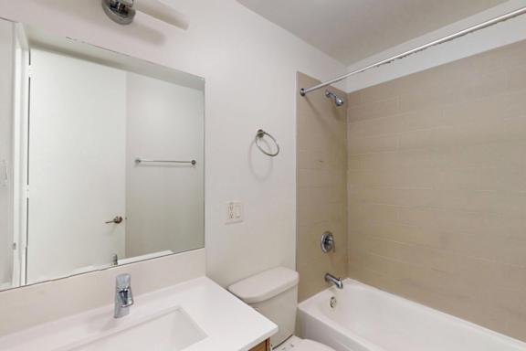 A white bathroom with a sink, toilet, and bathtub.