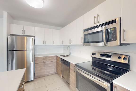A modern kitchen with stainless steel appliances and white cabinets.