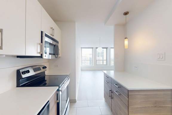 A kitchen with white cabinets and appliances.