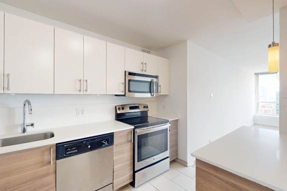 A modern kitchen with stainless steel appliances and wooden cabinets.