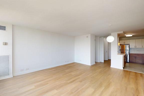 A room with wooden flooring and white walls.