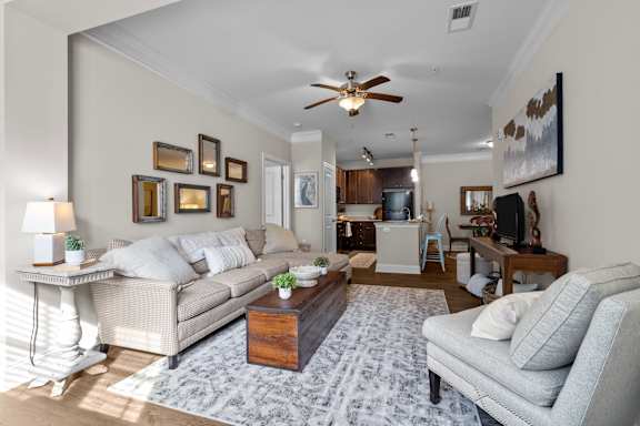 A living room with a couch, a coffee table, and a ceiling fan.