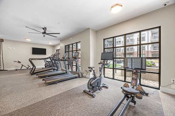 A spacious gym with treadmills, exercise bikes, and a television.at Adler Montford Park + Drexel Townes, North Carolina, 28209