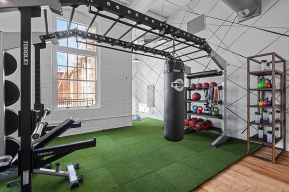 a gym with weights and a punching bag on a green rug at Spinning Mill Lofts, Clayton