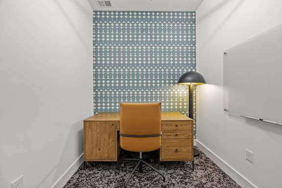 A room with a chair, a desk, and a lamp.at Adler Montford Park + Drexel Townes, North Carolina, 28209