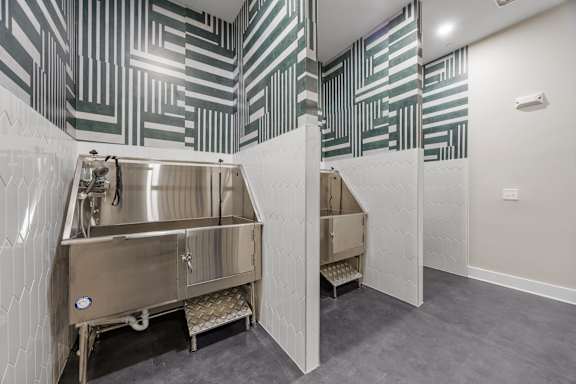 A stainless steel sink in a room with a black and white striped wallpaper.at Adler Montford Park + Drexel Townes, North Carolina, 28209