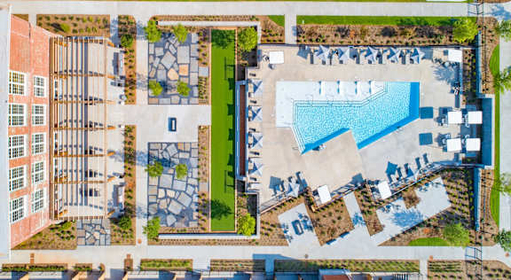 An aerial view of a building with a swimming pool and a courtyard with a fountain at Judson Mill Lofts, Greenville, South Carolina
