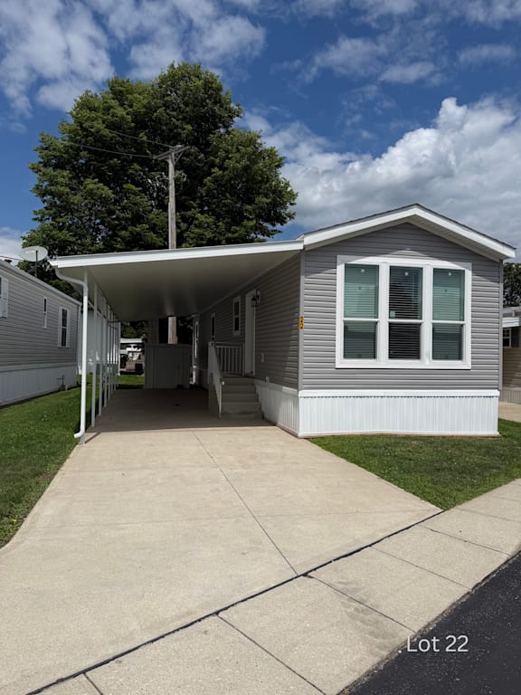 A small house with a porch and a white awning is labeled Lot 22.
