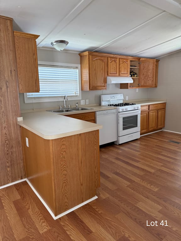 A kitchen with wooden cabinets and a white stove top oven.