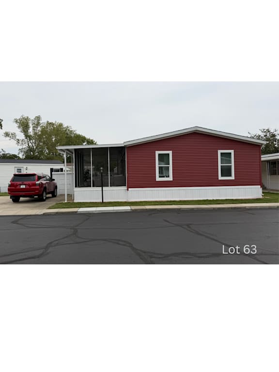 Floor Plan  A red building with a white fence and a red car parked in front.