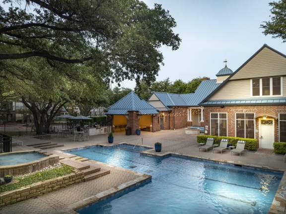 a swimming pool in front of a house with a resort style pool
