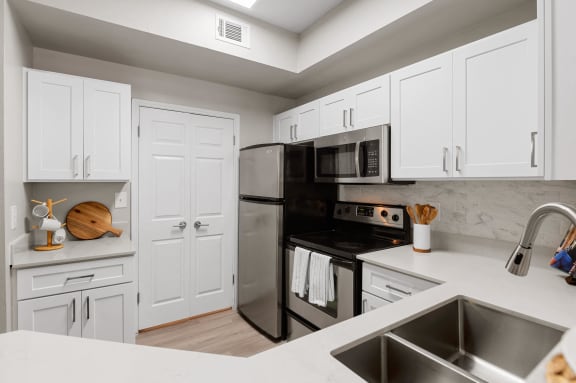 a kitchen with stainless steel appliances and white cabinets
