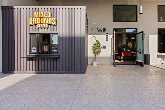 Coffee kiosk and courtyard entrance with paver walkway at AMP 30 Apartments, San Diego, California