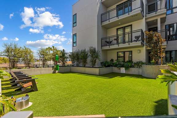 Courtyard with artificial turf and lounge chairs at AMP 30 Apartments, San Diego
