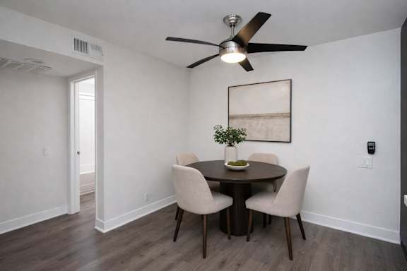 A dining room with a table and chairs.