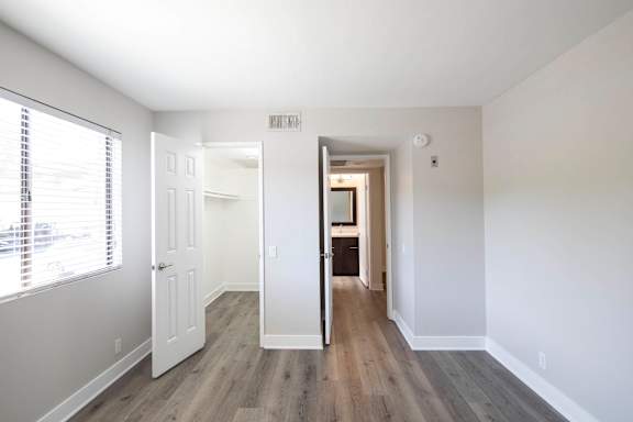 A room with a white door and a window with blinds.