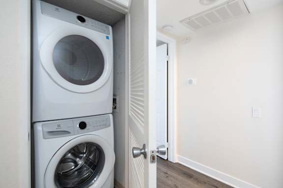 A white washing machine and dryer in a small laundry room.