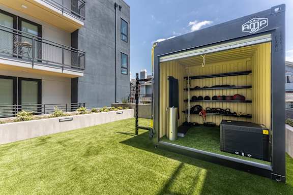 Outdoor fitness container with equipment storage and turf at AMP 30 Apartments, San Diego, 92116