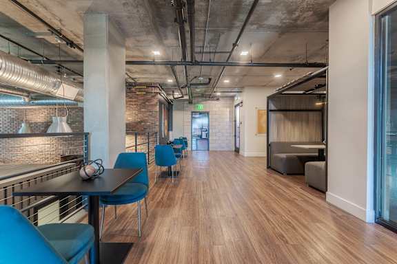 Industrial style communal workspace with blue chairs at AMP 30 Apartments, San Diego