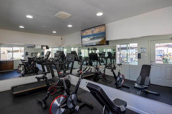 Gym with exercise bikes and weight benches at Bella Del Mar Apartments, California, 92014