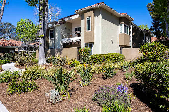 Multilevel building with stucco exterior and tile roof at Bella Del Mar Apartments, Del Mar, CA