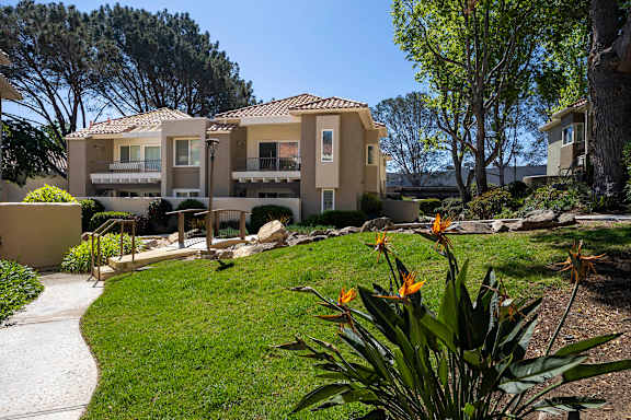 Grassy common area with bench and ornamental plants at Bella Del Mar Apartments, Del Mar, California