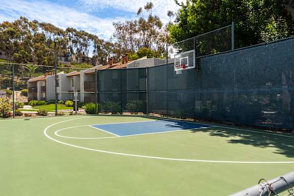 A basketball court with a blue court and a basketball hoop.