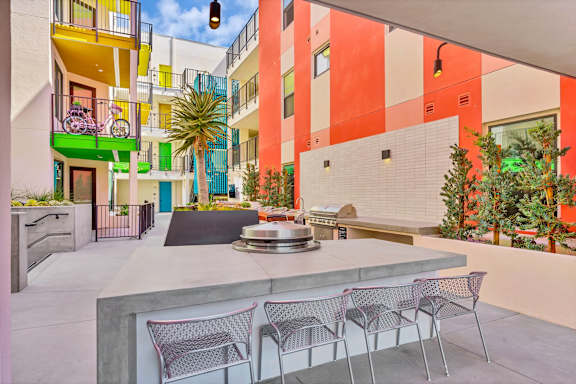A patio with a table and chairs is surrounded by a colorful building.