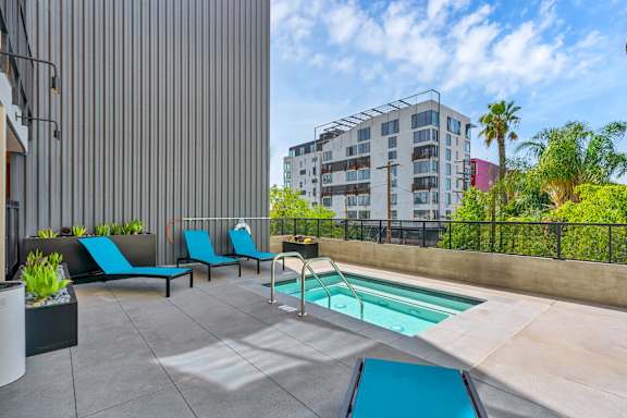 A pool area with a slide and loungers.